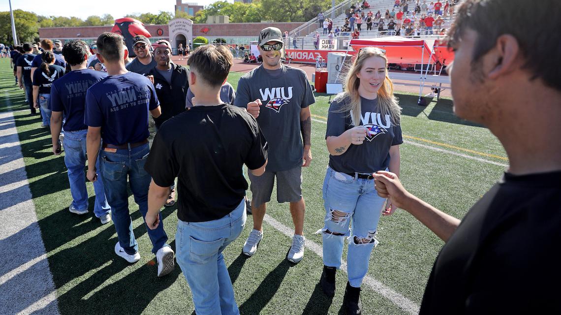 UIW student veterans thanking new military enlistees as they walk off the field 